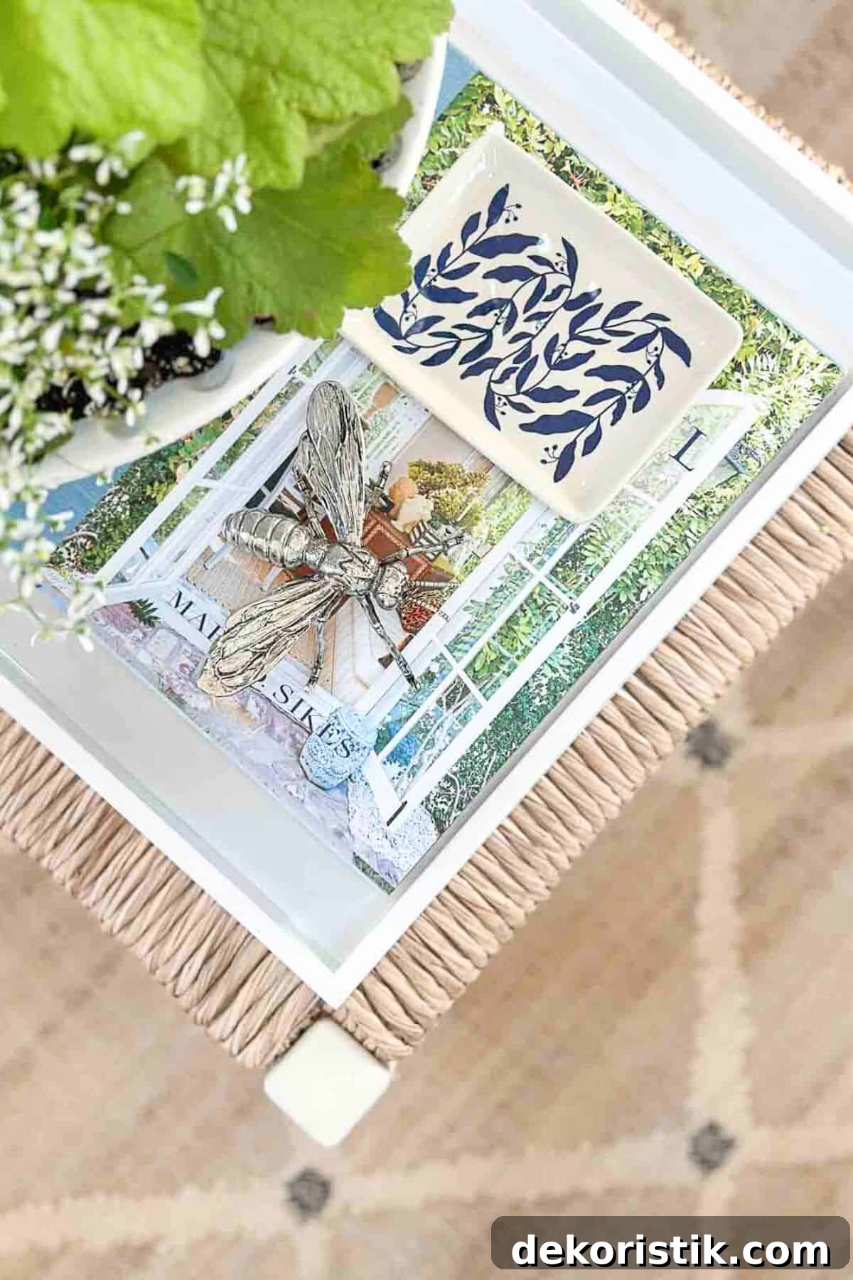stack of magazines and decor books in a white tray on a coffee table