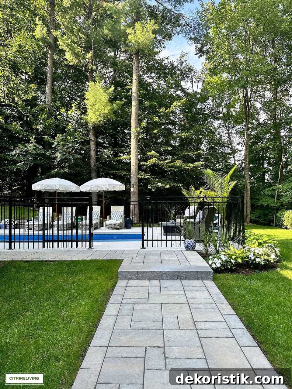 partial view of an in ground swimming pool with a black wrought iron fence