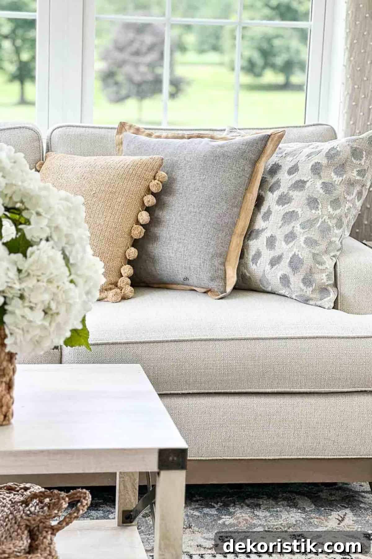 light gray sofa with tan, gray, and beige throw pillows