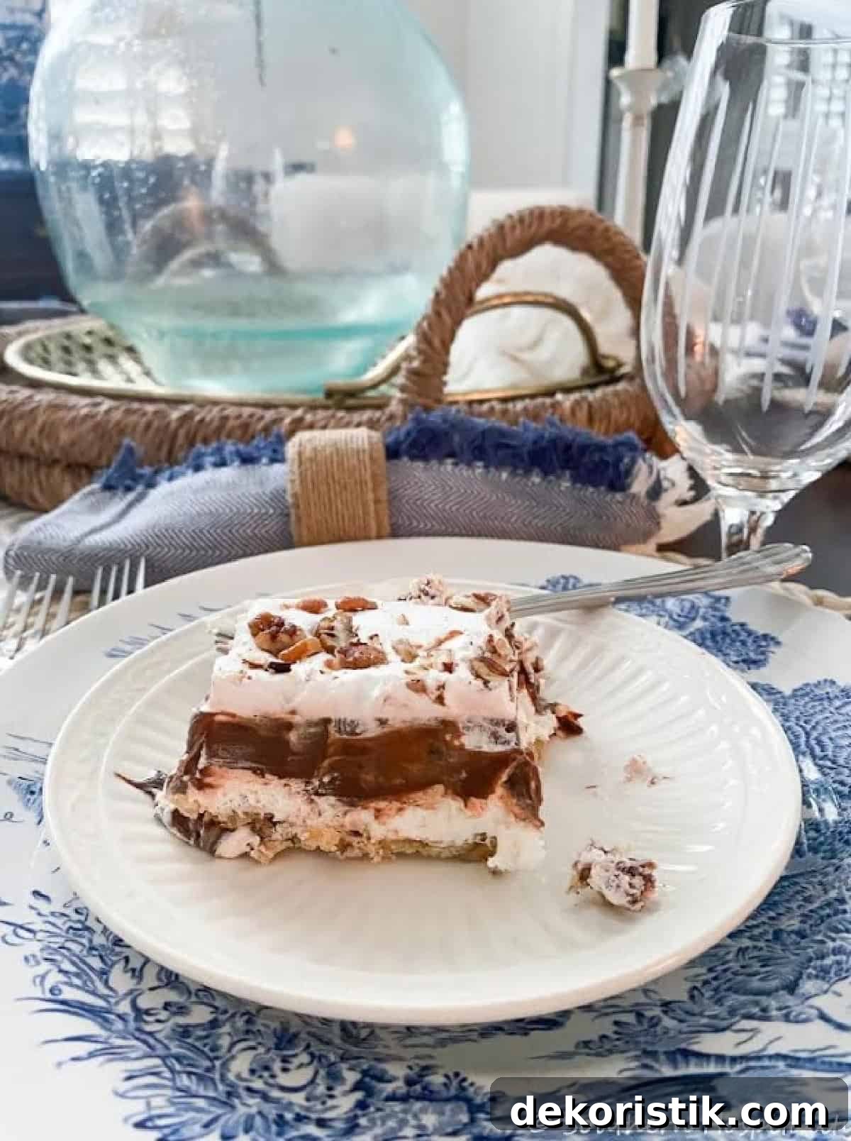 single pieces of chocolate yum yum dessert topped with chopped pecans on a white plate