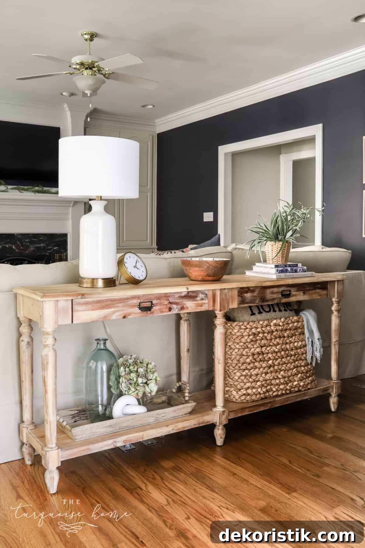 decorated sofa table behind a beige sofa in a living room with navy walls