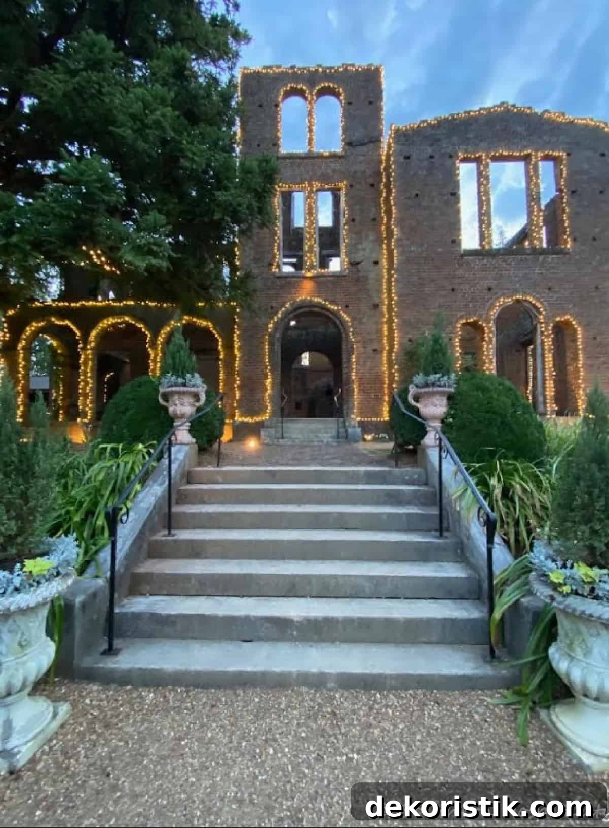 exterior of a gothic style brick home with windows and doors outlined with white lights.