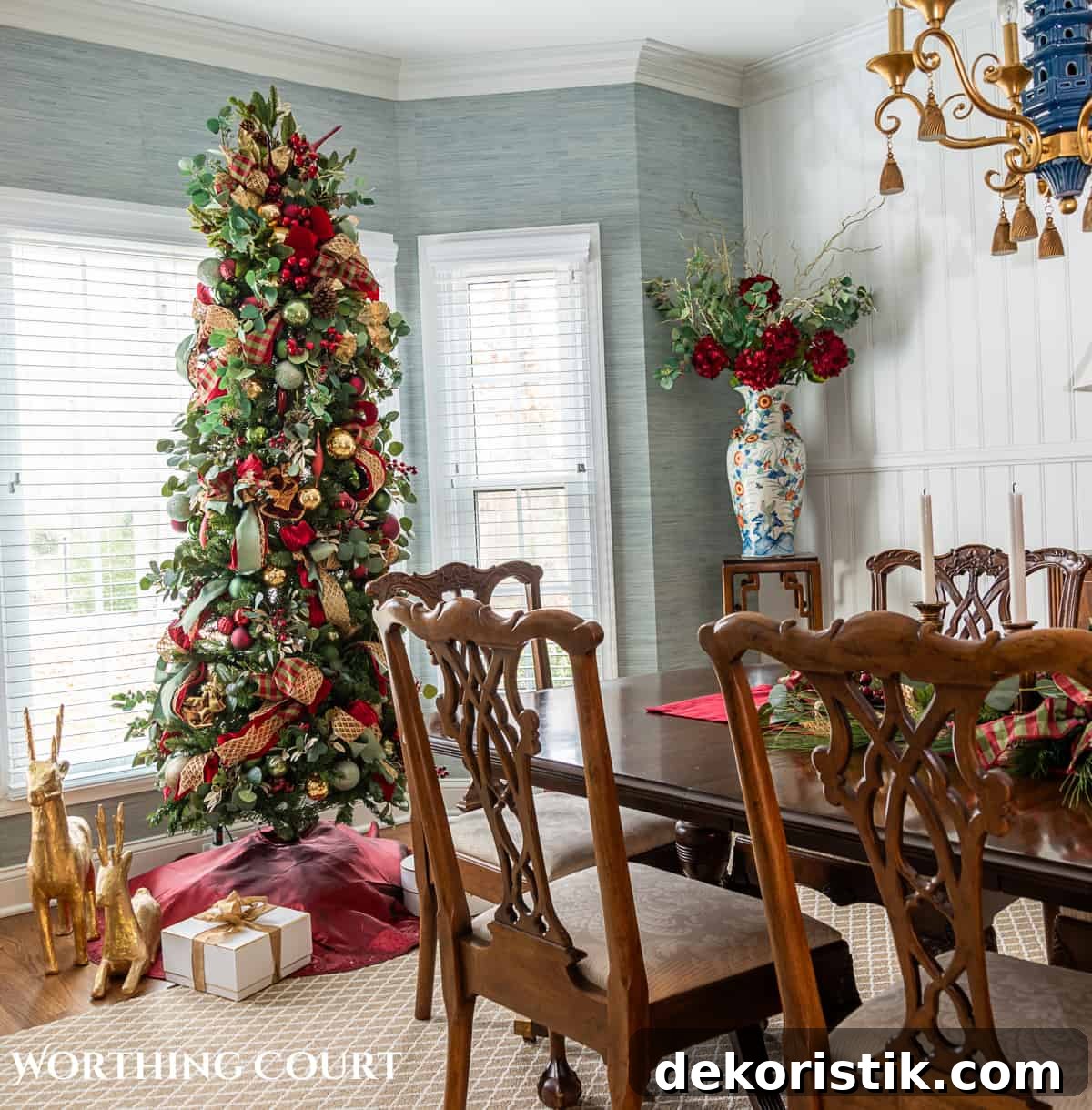 Dining room with traditional wood furniture decorated for Christmas with sage green, burgundy, and gold decorations.