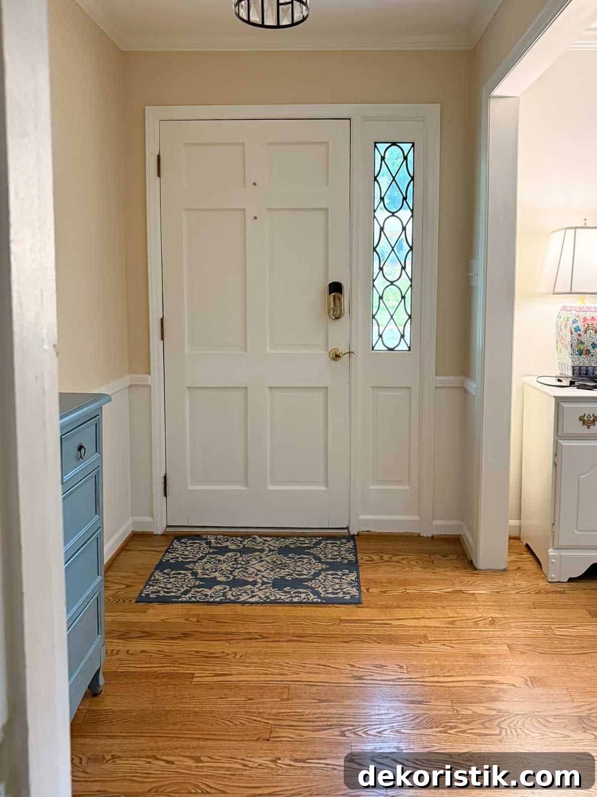 view of a small foyer with beige walls and a white front door with a sidelight