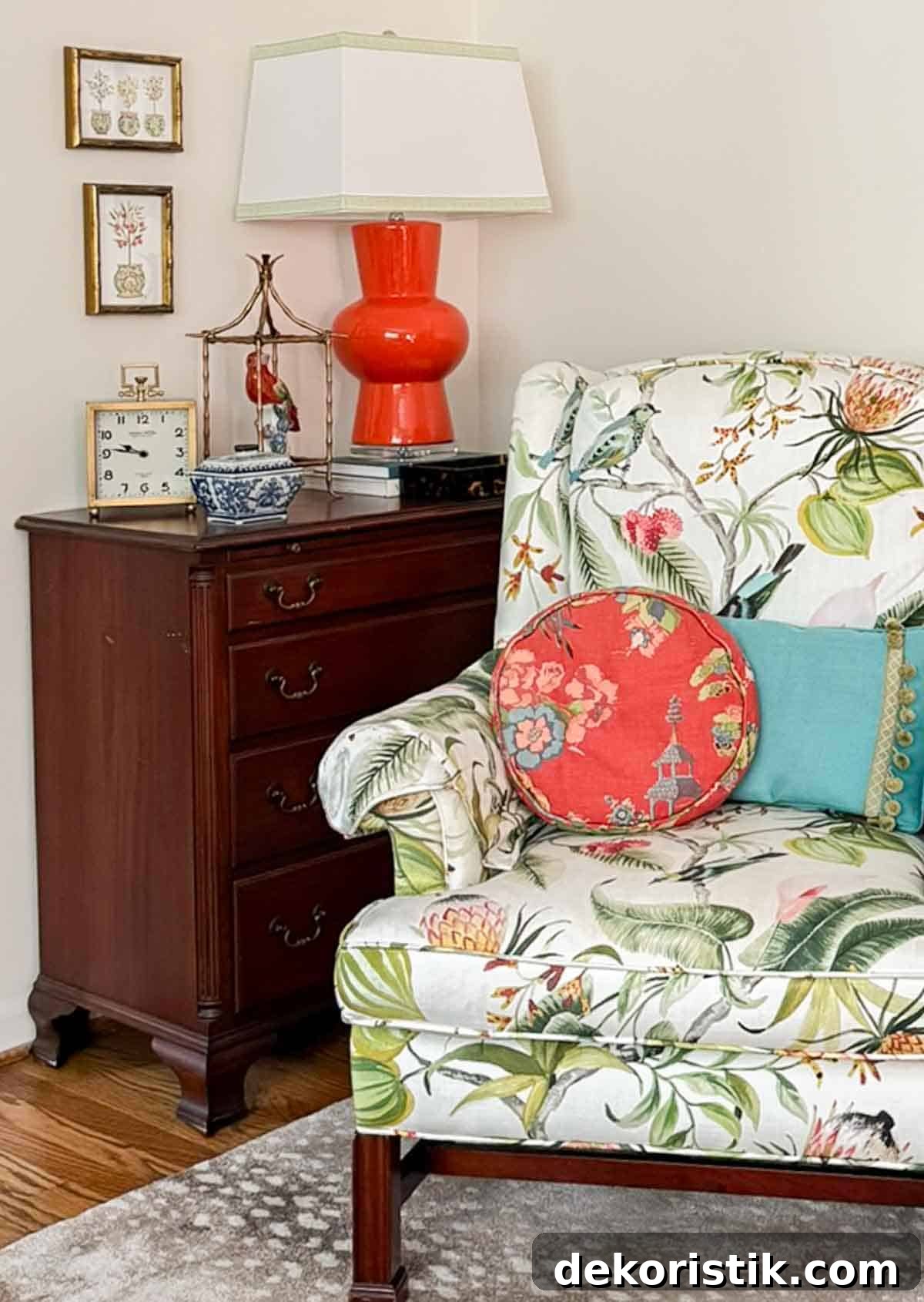 Small Living Room Ideas: How We Made Ours Stylish and Functional 10 partial view of a living room decorated with colorful patterns, chinoiserie accents, and traditional style furniture. Includes a blue velvet loveseat, faux bamboo bookcase, antelope print area rug, samsung frame tv in a gallery wall with art prints, framed needlepoint and plates, with coral accents