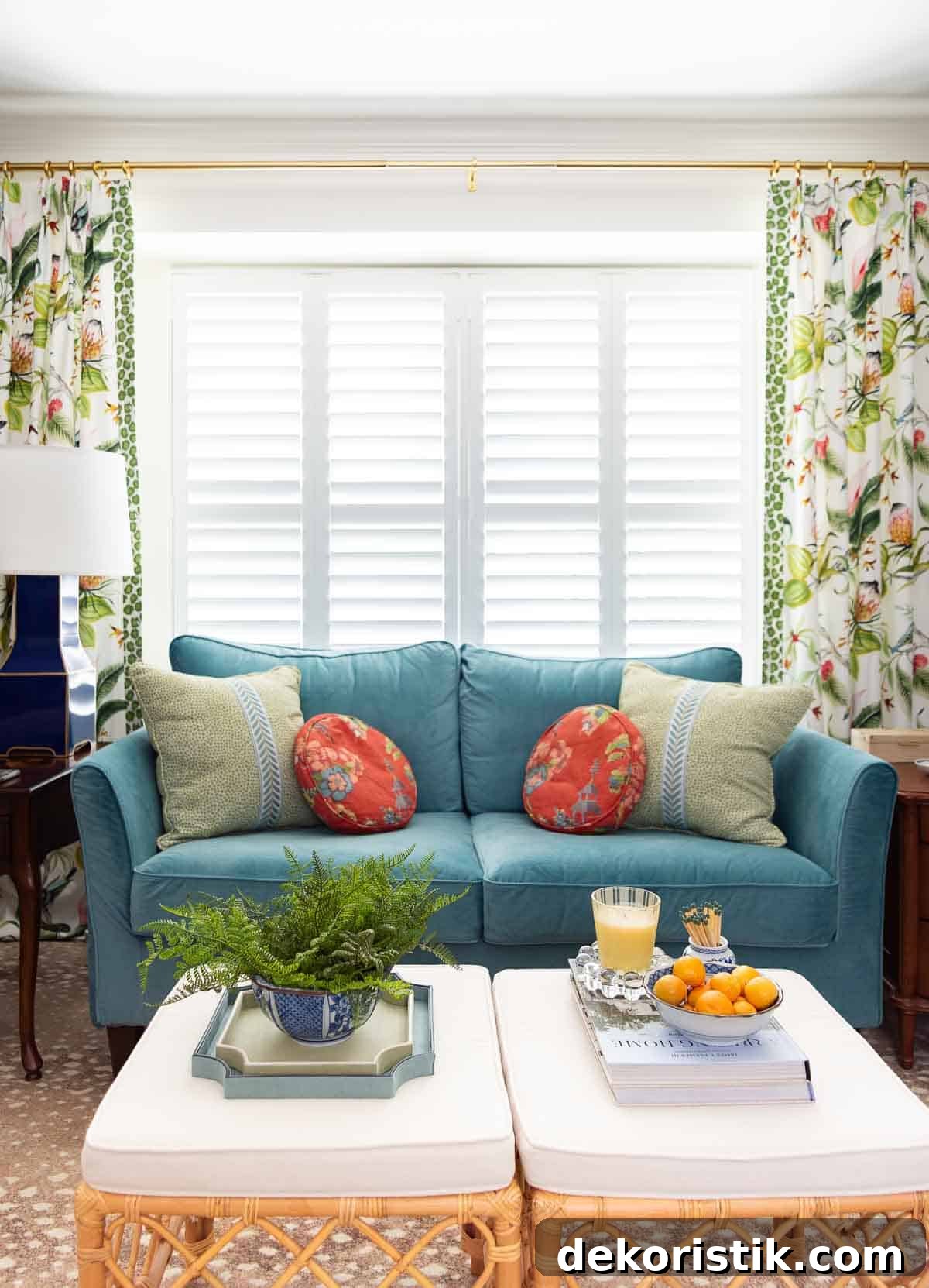 Small Living Room Ideas: How We Made Ours Stylish and Functional 7 blue velvet loveseat in front of a window with shutters flanked by colorful draperies