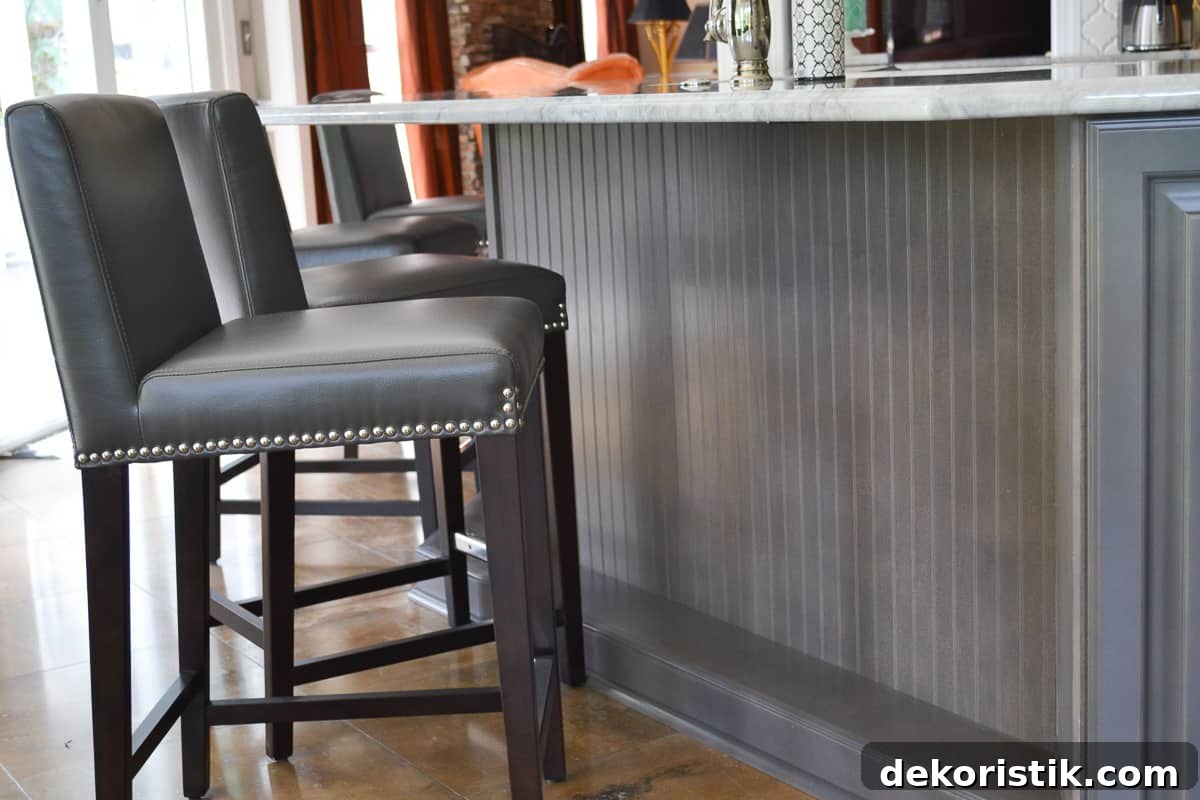 Stunning Kitchen Remodel: Before and After Reveal 10 front of gray kitchen island covered with beadboard paneling and gray leather barstools