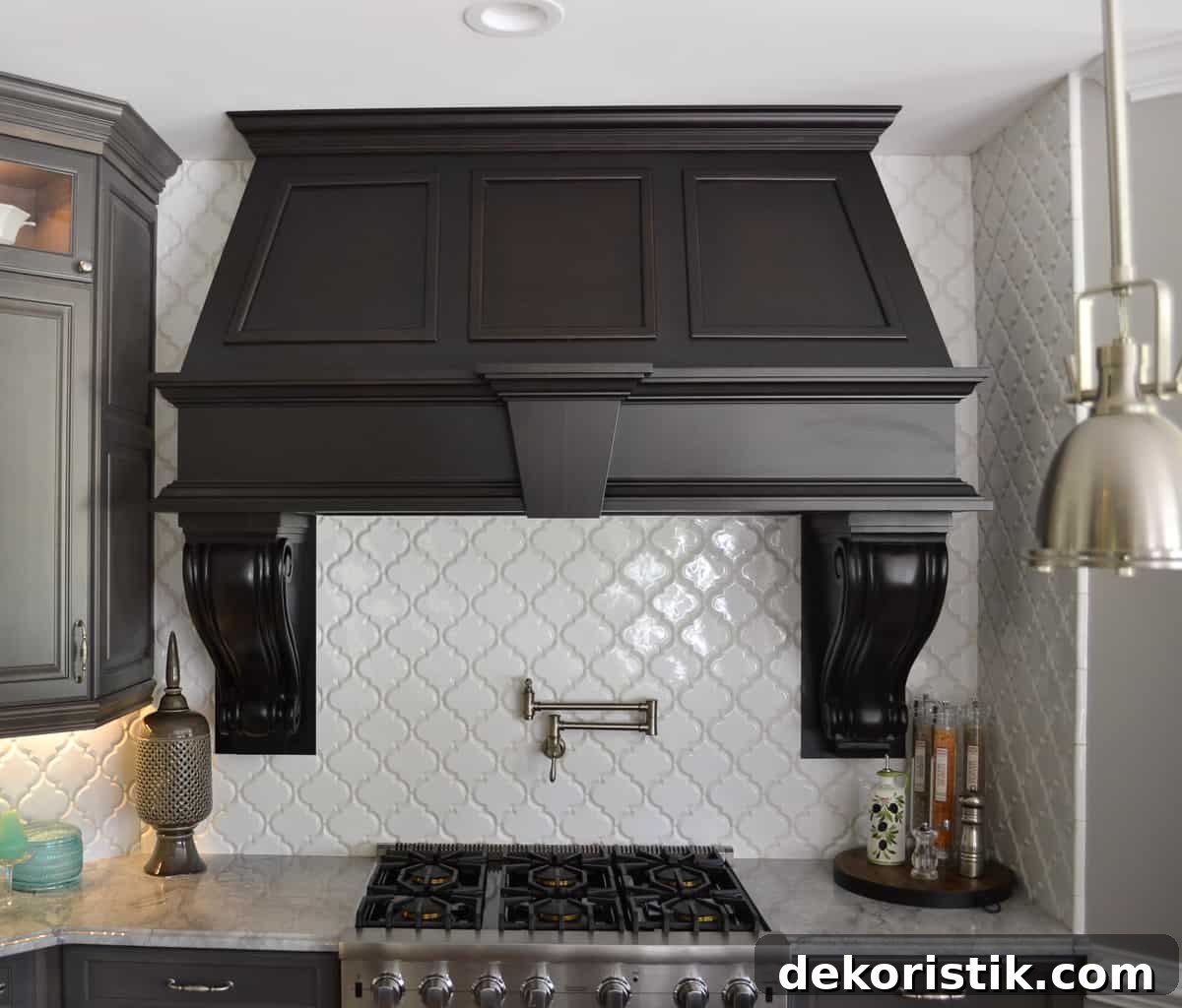 Stunning Kitchen Remodel: Before and After Reveal 3 huge custom black hood above a Viking range with a white quadrifoil tile backsplash