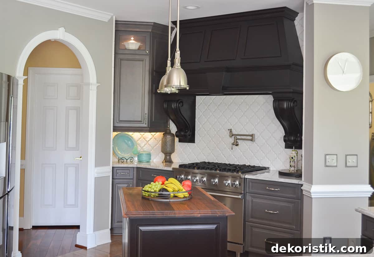 Stunning Kitchen Remodel: Before and After Reveal 4 huge custom black hood above a Viking range with a white quadrifoil tile backsplash
