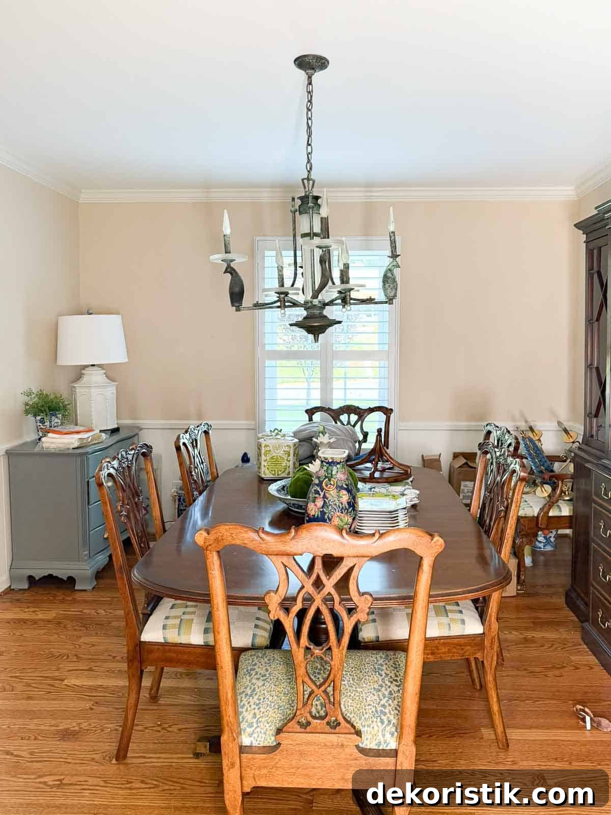 before image of a Traditional dining room with blue grasscloth walls, antique wood dining table and chairs, blue and white china, brass chandelier, and colorful chinoiserie accents.